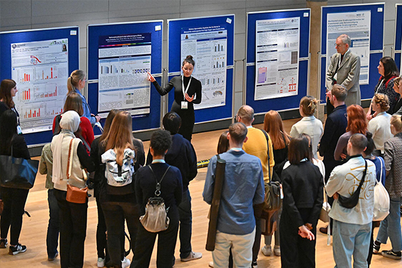Group of people standing in front of speakers and their posters